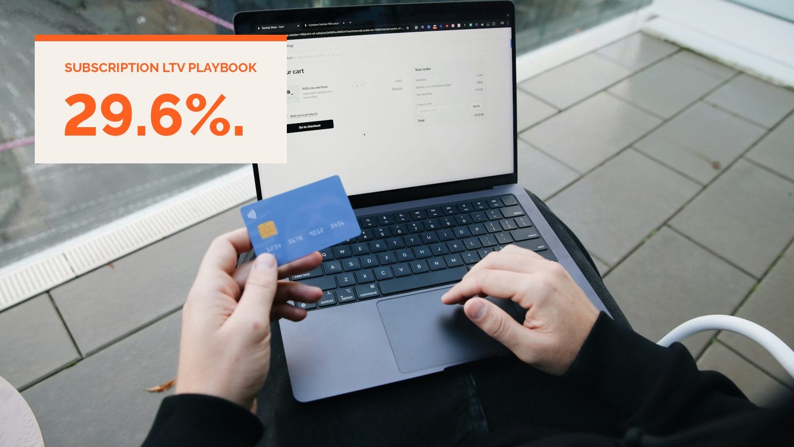 A person at a laptop holding a payment card