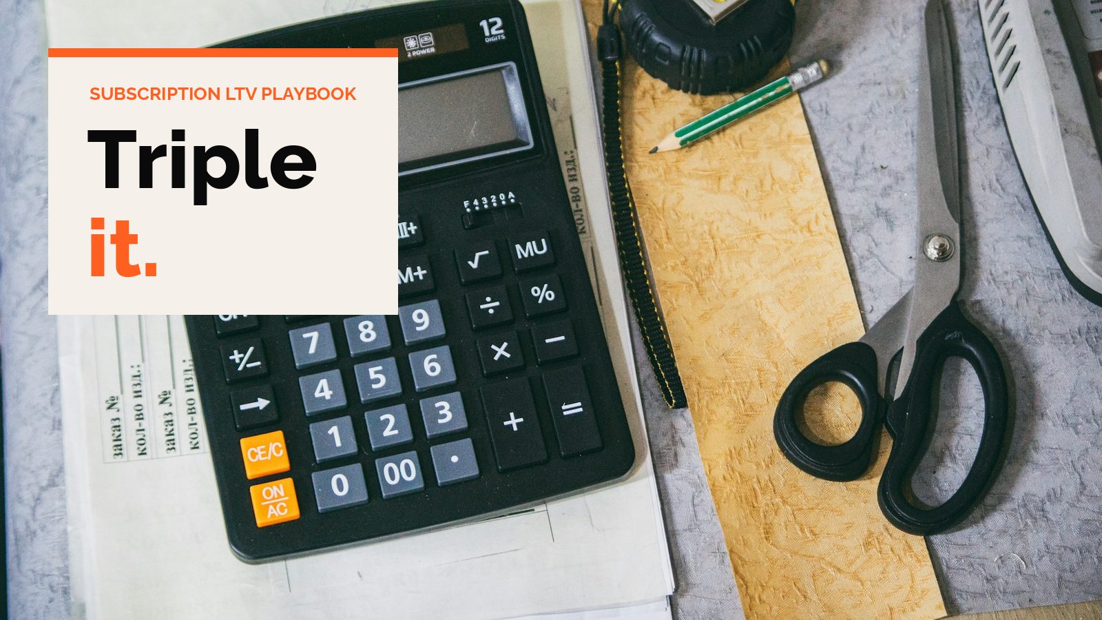 A desk calculator next to scissors and papers